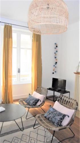 - un salon avec des chaises, une table et un piano dans l'établissement Le Sainte Barbe, à Saint-Malo