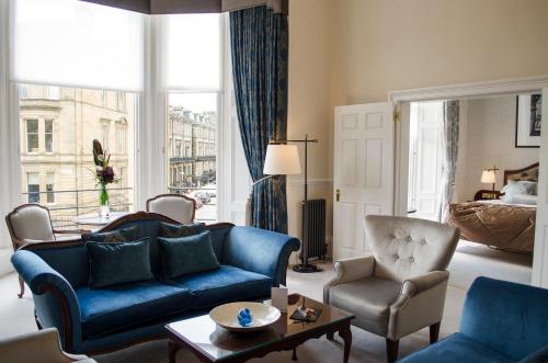 a living room with a blue couch and a chair at The Bonham in Edinburgh