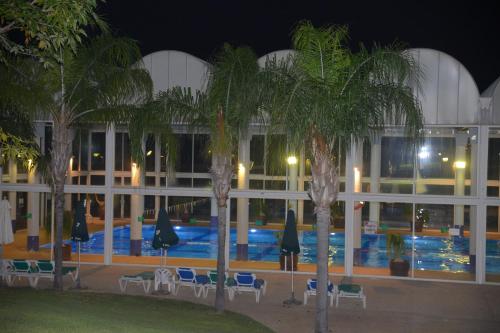 a hotel with a swimming pool at night at Liz suite in Caesarea