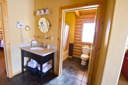 
a bathroom with a sink, toilet and mirror at Cody Cowboy Village in Cody
