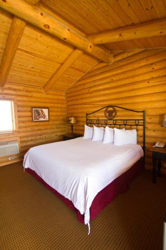 a bedroom with a large bed in a wooden room at Cody Cowboy Village in Cody