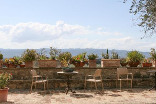 a patio with chairs and a table and potted plants at Country House Tre Esse in Assisi
