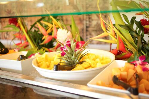 a counter with three bowls of food and flowers at OUTRIGGER Kaua'i Beach Resort & Spa in Lihue