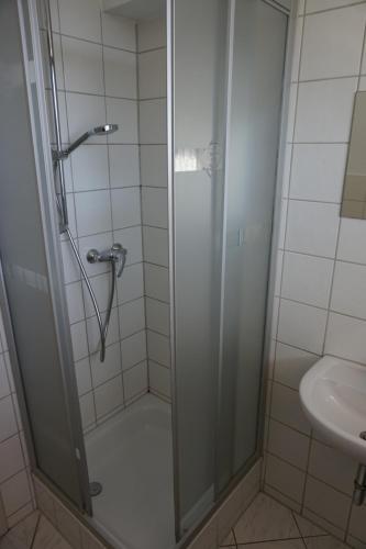 a shower with a glass door next to a sink at Monteurzimmer im Schwabenland in Donzdorf