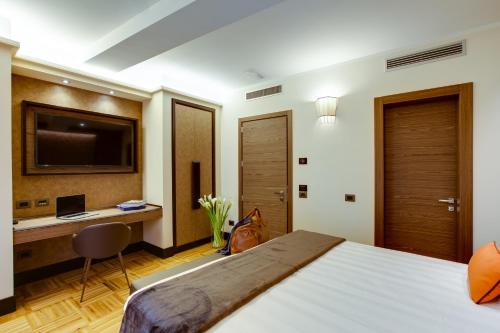 a bedroom with a bed and a desk with a computer at Solo Experience Hotel in Florence
