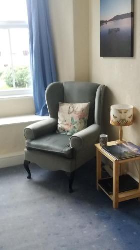a living room with a chair and a table at Plumtree House in Brigsteer