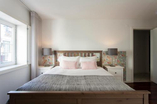 a bedroom with a large bed with pink pillows at Chiado Patio Apartment in Lisbon