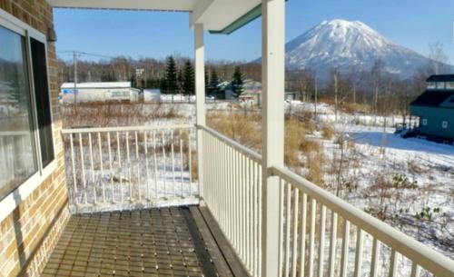 a balcony with a view of a snow covered mountain at Yotei Townhouse - 2 bedrooms with covered BBQ deck in Niseko