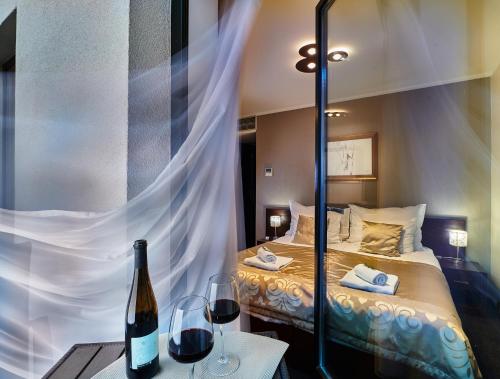 a bedroom with a bed with a mirror and wine glasses at Boutique Hotel Chrysso in Košice