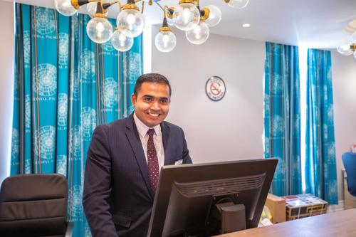 a man standing in front of a laptop computer at Best Western London Queens Crystal Palace in London