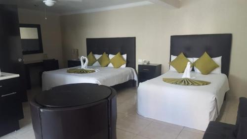 a hotel room with two beds with yellow pillows at Hotel Gya Boutique in Aguascalientes