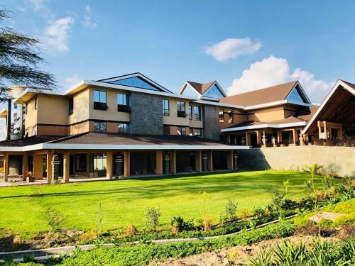 een groot huis met een groen gazon ervoor bij Lake Naivasha Resort in Naivasha