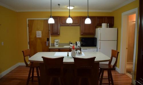 a kitchen with a table with chairs and a refrigerator at North Star Lodge & Resort in Killington