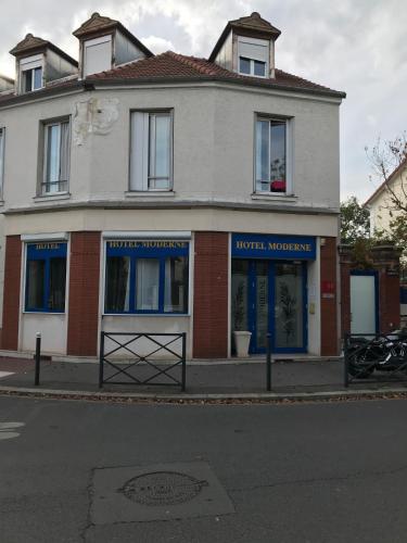 un bâtiment avec des fenêtres bleues sur une rue dans l'établissement Hotel Moderne, à Saint-Maur-des-Fossés