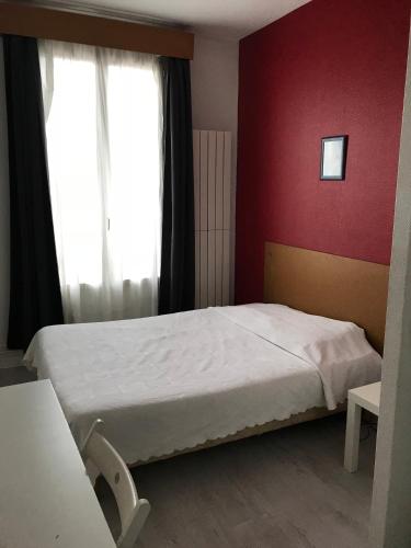 サン・モール・デ・フォッセにあるHotel Moderneの赤い壁のベッドルーム1室(ベッド1台付)