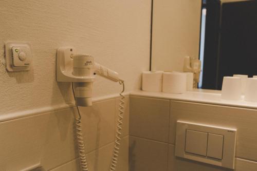 a hair dryer on the wall of a bathroom at Appartement Sport Girbl in Strobl