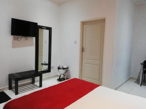 um quarto com uma cama com um espelho e um tapete vermelho em Mashusha Guest House em Bokaa