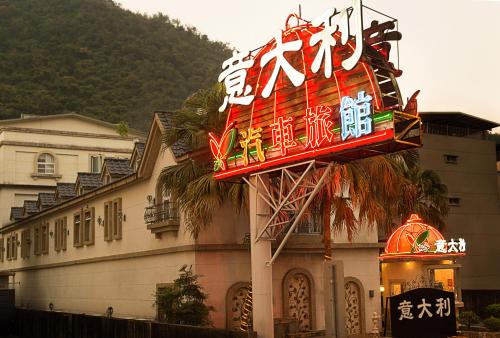 a sign for a hotel in front of a building at 意大利溫泉會館 in Jiaoxi