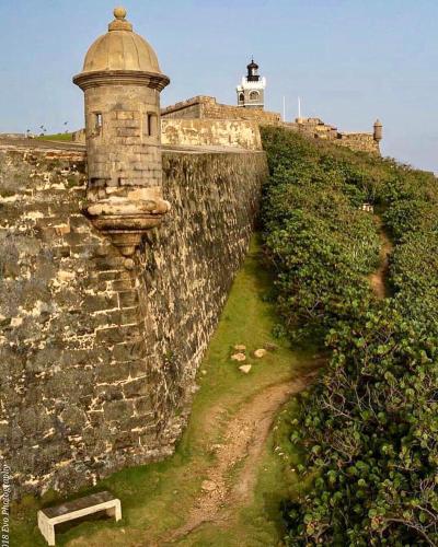 a stone wall with a lighthouse on top of it at Navona Studios in San Juan