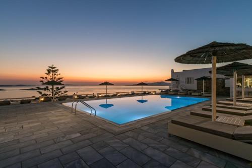 a swimming pool with a sunset in the background at Hotel Alkyon in Mýkonos City