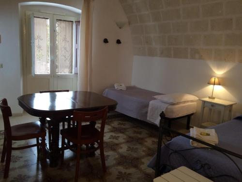 マッサフラにあるB&B Corte Laterzaのテーブル、ベッド、窓が備わる小さな客室です。