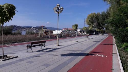 a sidewalk with a bench and a street light at Park Golden Beach Tasevski in Ohrid