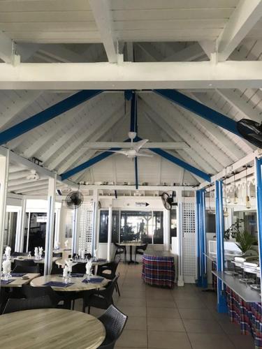 a restaurant with tables and chairs and a ceiling at Canella Beach Hotel in Le Gosier