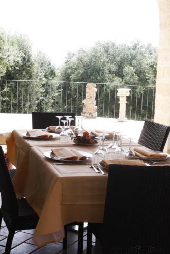 a table with chairs and a table cloth on it at Masseria Ruri Pulcra in Patù