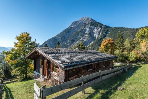 a log cabin with a mountain in the background at Ropferhof in Telfs-Buchen