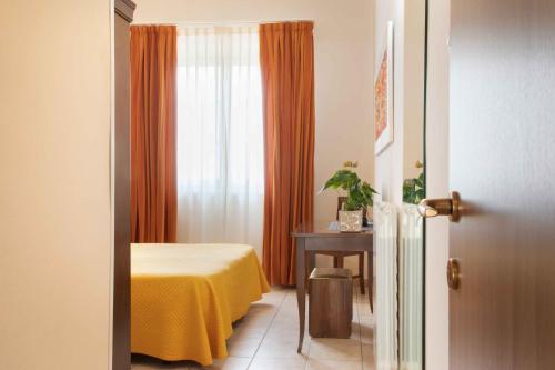 a room with a bed and a table and a window at Al Frantoio Maddii Levane bed and breakfast in Levane