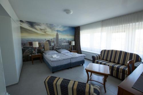 a bedroom with a bed and a living room with a couch at City Hotel Wuppertal in Wuppertal