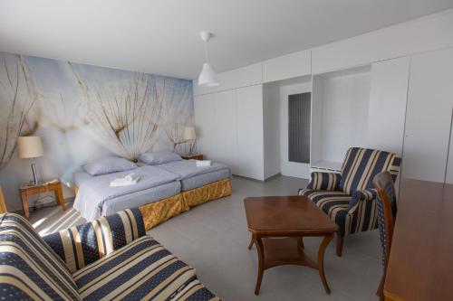 ヴッパータールにあるCity Hotel Wuppertalのベッド1台と椅子2脚が備わるホテルルームです。