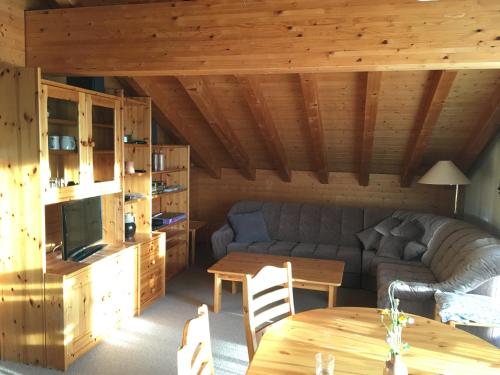 a living room with a couch and a table at Chalet Orchis in Hasliberg Wasserwendi