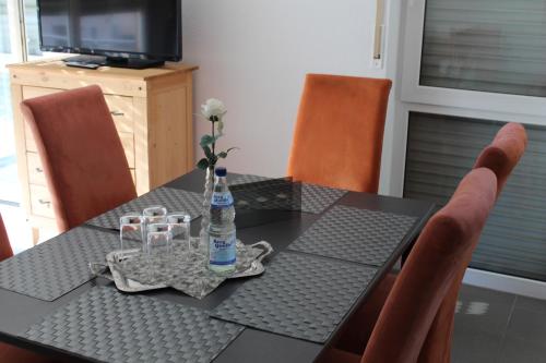 a dining room table with a bottle of water and chairs at Ferienwohnung Tropical in Vendersheim