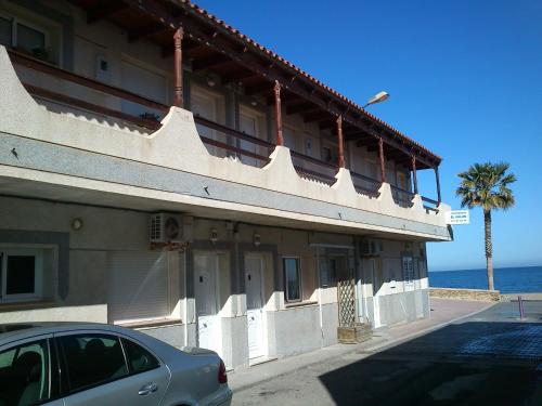 un edificio con un coche aparcado delante en Apartamentos El Galán, en Carboneras