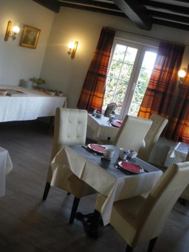 een kamer met een tafel en stoelen en een bed bij Hotel Amaryllis in Maldegem