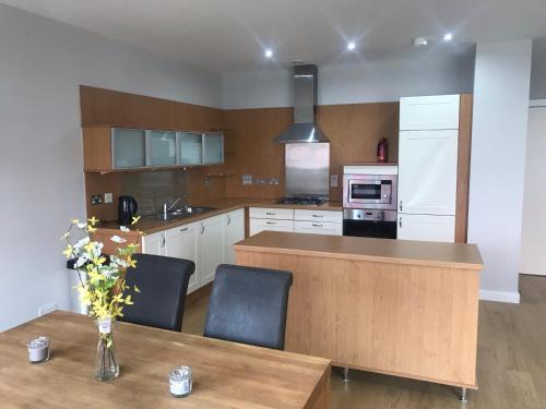 a kitchen with a wooden counter and a table with chairs at Elegant Apartment Near SECC/HYDRO in Finnieston, Glasgow in Glasgow