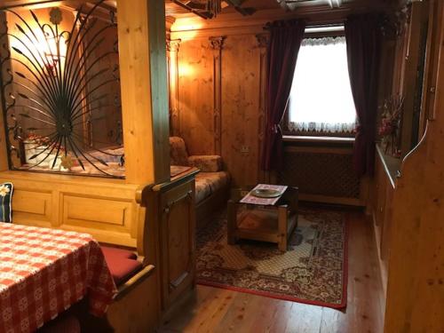 een slaapkamer met een bed, een raam en een tafel bij Sweet Home in Cortina dʼAmpezzo