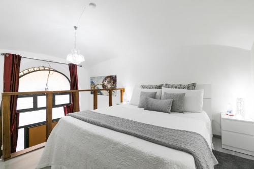 a white bedroom with a bed and a window at Diana Luxury Loft in Rome