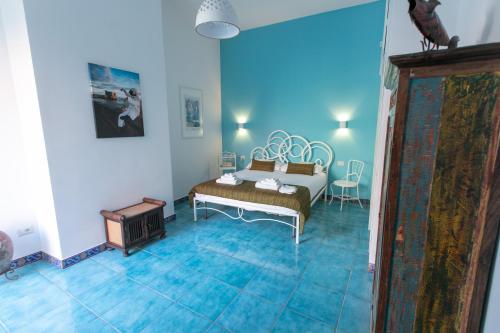 1 dormitorio con 1 cama en una habitación azul en Sebeto Bellini, en Nápoles