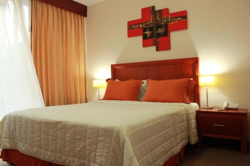 a bedroom with a bed with a red cross on the wall at Hotel Samuria in Zamora