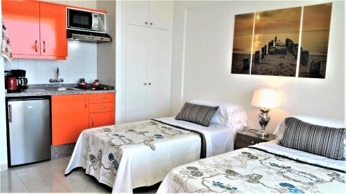 プラヤ・デ・ラス・アメリカスにあるLas Americas Panoramic Sea Viewsのキッチン(ベッド2台付)が備わる小さな客室です。