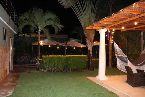 a patio at night with umbrellas and palm trees at Jaco Sol Quadplex 11A in Jacó