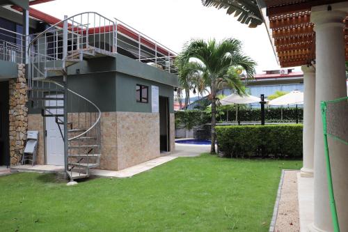 a spiral staircase on the side of a building with a yard at Jaco Sol Quadplex 11A in Jacó