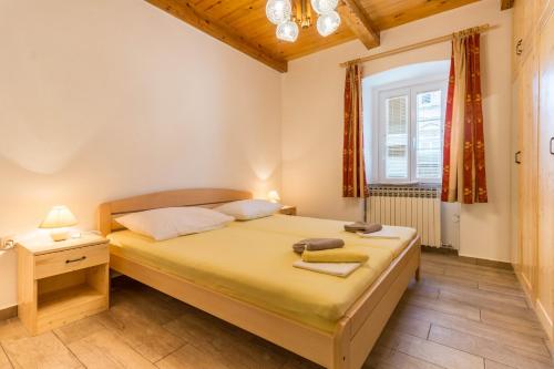 a small bedroom with a bed and a window at APARTMAN ŠARE in Crikvenica