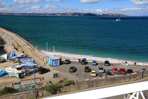 a parking lot next to the beach with cars parked at Devoncourt Devoncoast SeaView Apartments in Brixham