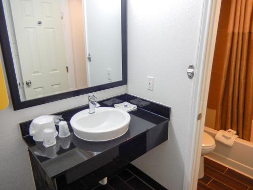 y baño con lavabo, espejo y aseo. en Motel 6-Portland, TX, en Portland