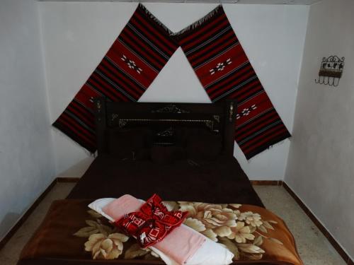 a bed with red and black striped pillows on it at Dana Tower Hotel in Dana