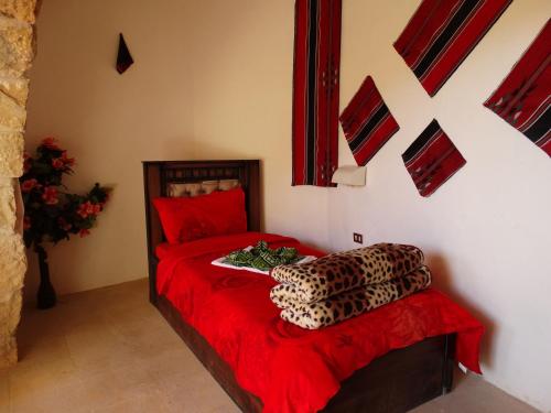 a bedroom with a leopard bed with red sheets and a red blanket at Dana Tower Hotel in Dana