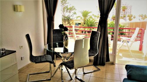 une salle à manger avec une table et des chaises en verre dans l'établissement Playa de Las Americas Sea Views II, à Playa de las Americas